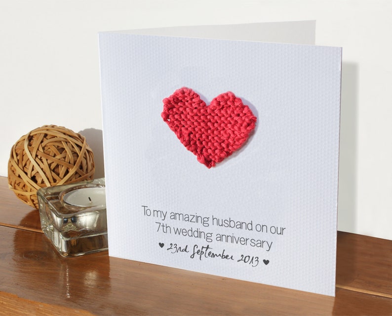May include: A white card with a red knitted heart and the text "To my amazing husband on our 7th wedding anniversary &hearts; 23rd September 2013 &hearts;".