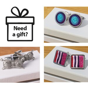 May include: A set of four cufflinks with different designs. The first pair features a blue and purple swirl design. The second pair features a pink and purple striped design. The third pair features a silver ball of yarn with the word "wool" on it. The fourth pair features a silver ball of yarn with the word "wool" on it.