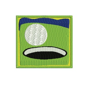 Könnte beinhalten: Gestickter Aufnäher mit Golf-Motiv. Das Design zeigt einen weißen Golfball, ein grünes Feld, ein schwarzes Loch und einen blauen Himmel. Der Aufnäher ist quadratisch mit gelbem Rand.
