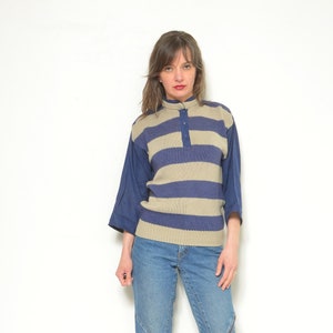 Puede incluir: Una mujer con un suéter a rayas de color azul y beige, jeans azules y zapatos de tacón azul oscuro.