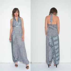 May include: A gray and blue patterned halter top jumpsuit with a silver trim. The jumpsuit has a wide leg and a loose fit.