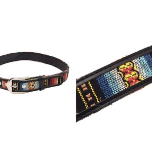 Peut inclure: Une ceinture noire tissée avec une boucle argentée. La ceinture présente un motif géométrique coloré dans des tons de rouge, bleu, jaune et blanc.