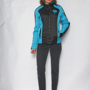 May include: A blue and black jacket with a zipper closure and a logo on the chest. The jacket has a sporty style.