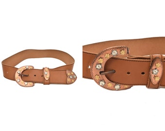 Cinturón ancho vintage de cuero auténtico marrón de los años 90 con hebilla grande de metal y símbolos florales.