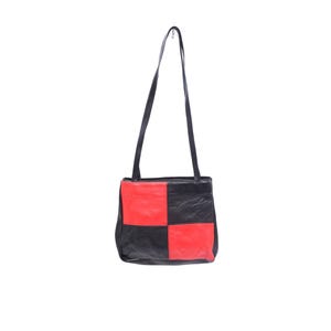 May include: A shoulder bag featuring a checkerboard pattern of black and red leather panels. The bag has two long, thin black leather shoulder straps attached to the top edge, creating a rectangular silhouette with a smooth, consistent texture.