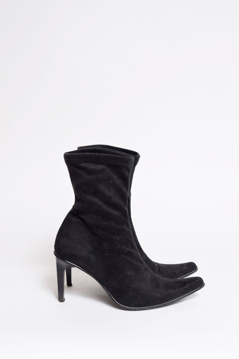 May include: Black suede ankle boots with a pointed toe and stiletto heel.