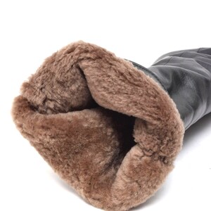 May include: Black leather boots with a brown faux fur lining. The boots are turned inside out to show the lining.