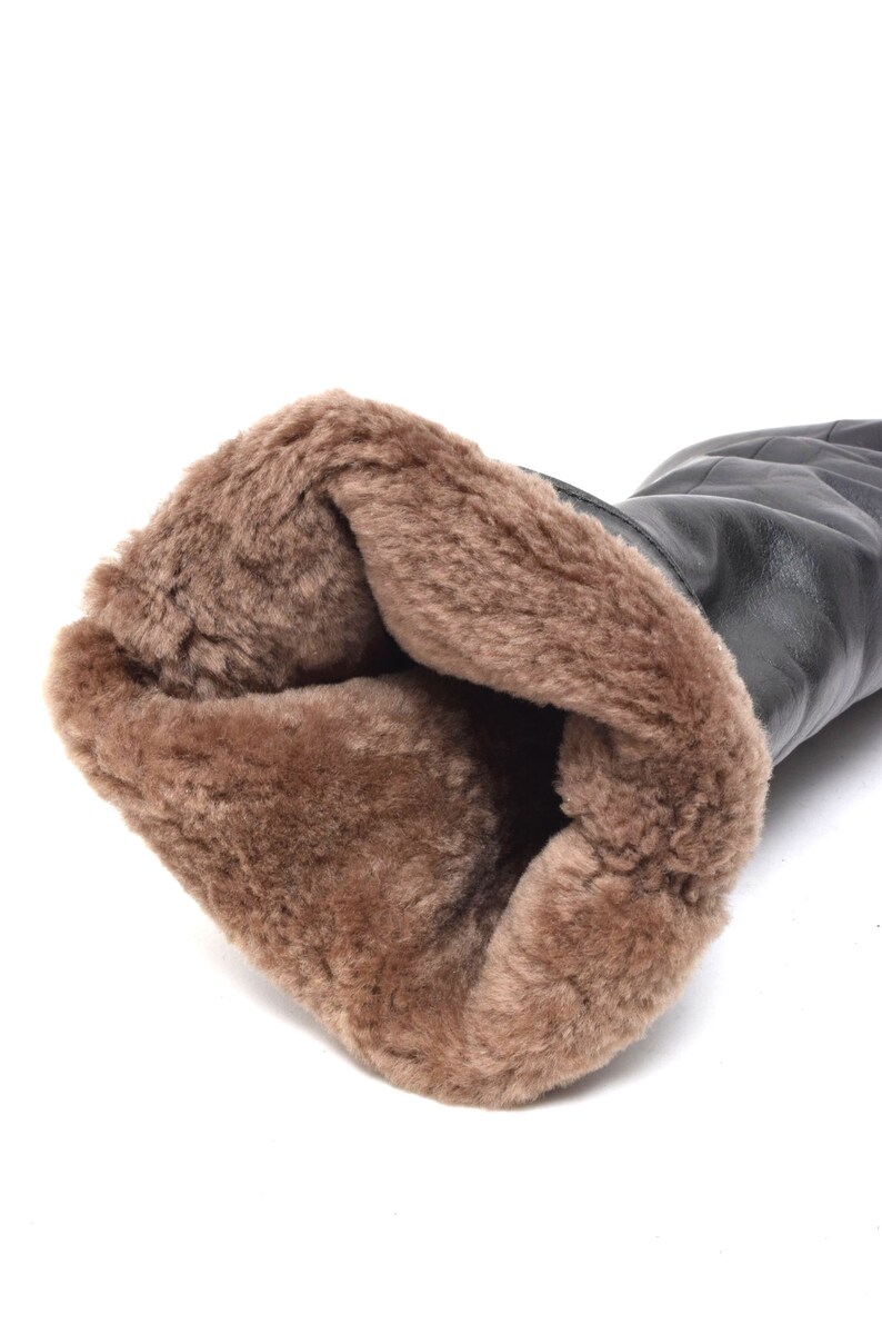May include: Black leather boots with a brown faux fur lining. The boots are turned inside out to show the lining.