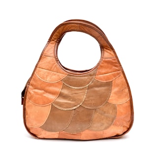 May include: A brown leather handbag with a patchwork design. The bag has a single handle and a flap closure.
