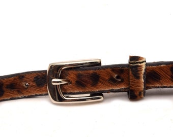 May include: A brown and black leopard print belt with a silver buckle.