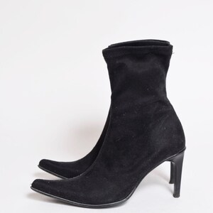 May include: Black suede ankle boots with a pointed toe and a stiletto heel.