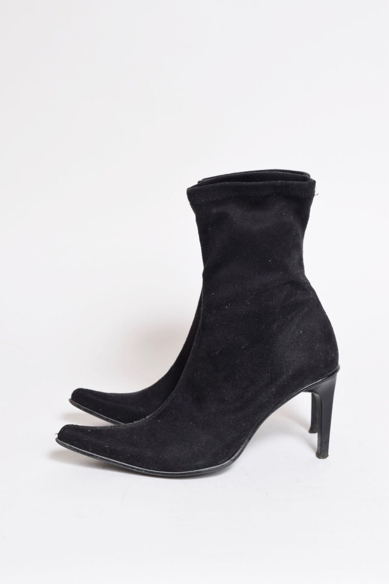 May include: Black suede ankle boots with a pointed toe and a stiletto heel.