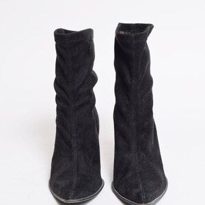 May include: A pair of black suede ankle boots with a pointed toe and a low heel.