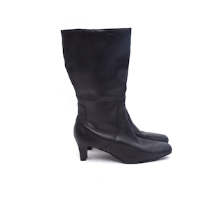 May include: Black leather knee-high boots with a low heel.