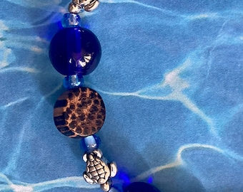 Handcrafted beaded bracelet. Beautiful cobalt blue glass, wood and silver turtle beads. Original. M-L size. Ships in nice gift bag.