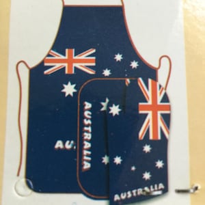 Op de afbeelding: Een blauwe schort met de Australische vlag erop gedrukt. De schort heeft de tekst "Australia" erop gedrukt in witte letters.