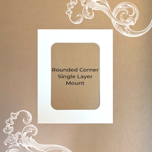 May include: White mount board with rounded corners and a single layer mount. The text "Rounded Corner Single Layer Mount" is printed on the mount.