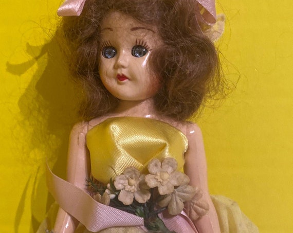 Vintage hard plastic doll in yellow dress
