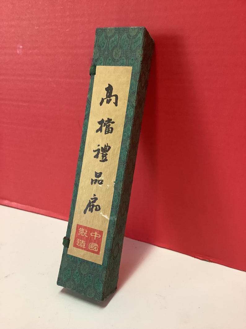 K&ouml;nnte beinhalten: Eine gr&uuml;ne Schachtel mit chinesischen Schriftzeichen auf einem Etikett. Das Etikett lautet "Qing-Dynastie" und "Hergestellt in China".