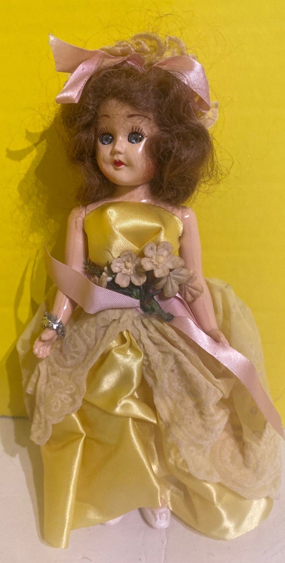 Vintage hard plastic doll in yellow dress