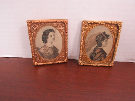 Miniature pair of metal picture frames with prints