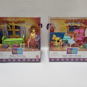 May include: Two boxed Winnie the Pooh playsets from the Comfy Corners collection. The left box features Pooh's Bedroom with a green bed and Pooh figure. The right box shows Kanga & Roo's Nursery with a yellow rocking horse and Kanga figure.