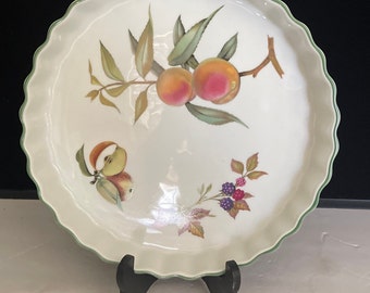 May include: White ceramic baking dish with a green scalloped rim. The dish features a painted design of peaches, apples, and blackberries.