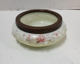May include: A white glass bowl with a floral design and a copper rim. The bowl has a delicate floral pattern with pink and white flowers.
