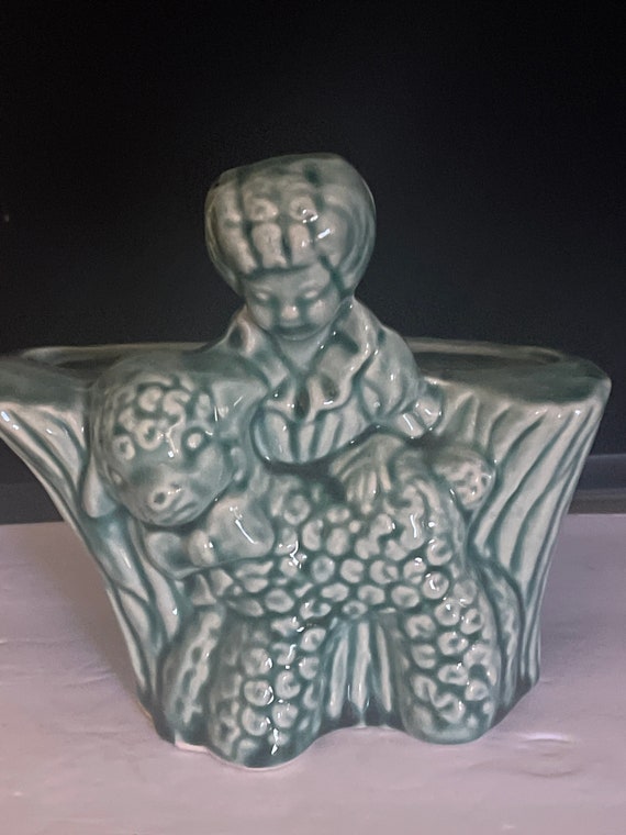 Green vase or planter with child and lamb