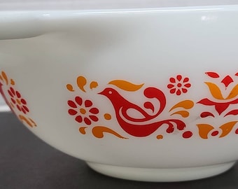 May include: White ceramic mixing bowl with a red and orange floral design. The design features stylized birds and flowers.