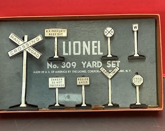 May include: A vintage Lionel No. 309 Yard Set model train accessory box with a white background and black lettering. The box contains eight different signs, including a railroad crossing sign, a danger do not trespass sign, a reduce speed sign, a yard limit sign, a stop sign, a railroad property keep out sign, and two railroad crossing signs.