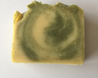 May include: A bar of handmade soap with a swirl pattern of green and yellow.
