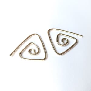 Puede incluir: Un par de pendientes de plata en forma de triángulo con un diseño en espiral en el centro de cada triángulo.