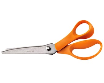 Puede incluir: Tijeras de tela con mangos naranjas y una hoja plateada, con la palabra "FISKARS" impresa en la hoja.
