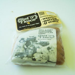 May include: A package of Feel o' Fleece mock wool fiber. The package is brown and has a picture of dolls with different hairstyles. The text on the package reads "Feel o' Fleece The Jack of All Crafts' Fiber 100% Soft Acrylic Mock Wool Fiber Textural Fiber for weaving macrame & crafts Doll & Soft Sculpture Hair Styles Using Feel o' Fleece Mock Wool Fiber".