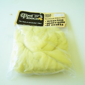 May include: A package of yellow "Feel o' Fleece" mock wool tops. The package label reads "The Jack of All Crafts" Fiber, 100% Soft Acrylic. It is a textural fiber for weaving, macrame, and crafts.