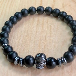 Men&#39;s stretchy Onyx Hematite gemstone bead bracelet featuring Hematite skull (Kutsa).