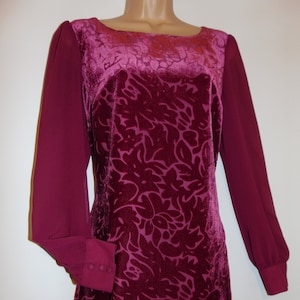 May include: A long-sleeved dress with a burgundy velvet bodice and sheer burgundy sleeves. The bodice has a floral pattern.