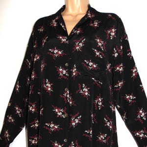 Può includere: Camicia nera a maniche lunghe con bottoni e stampa floreale in tonalità di bianco, rosso e crema.