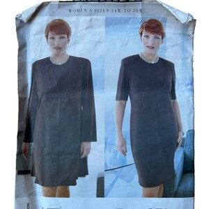 May include: A vintage sewing pattern by Tamotsu for women's sizes 14W to 30W. The pattern features two dress designs, one with long sleeves and a coat, and the other with short sleeves. The pattern number is 2169.