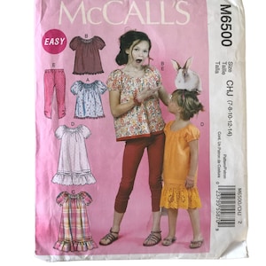 May include: A sewing pattern for girls' clothing sizes 7-8, 10-12, and 14. The pattern includes instructions for making a dress, a top, and pants. The pattern is from McCall's and is labeled "Easy".