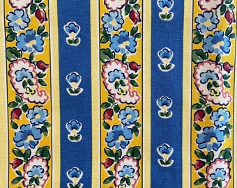 May include: A yellow and blue striped fabric with a repeating pattern of blue flowers and paisley shapes.