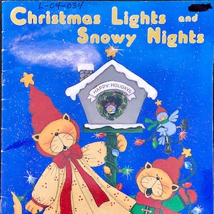 May include: A Christmas-themed illustration featuring two cats dressed in festive attire. One cat is wearing a red and white dress and holding a string of Christmas lights. The other cat is wearing a green and red outfit and is holding a string of lights. The illustration is set against a blue background with a birdhouse and a blue bird.