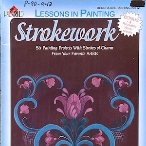 May include: A book cover for "Lessons in Painting: Strokework" with a floral design in pink and blue on a dark brown background. The cover includes the text "Six Painting Projects With Strokes of Charm" and "Featuring FolkArt Acrylic Colors."