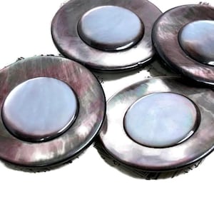 May include: Four round, iridescent black and grey mother of pearl buttons with a raised, white center.