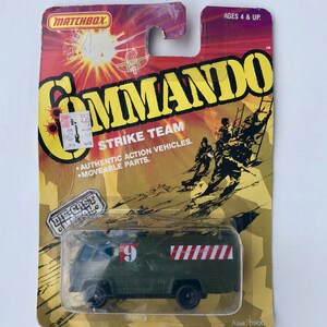 May include: A green Matchbox Commando Strike Team die-cast toy truck with a red and white striped design on the side. The truck has a number 9 on the side and the words "Die-Cast Metal" on the packaging.
