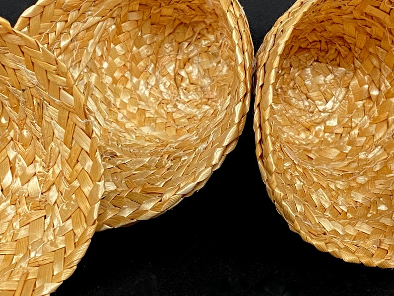 Pu&ograve; includere: Primo piano di tre cappelli di paglia intrecciata. I cappelli sono di colore marrone chiaro e hanno un motivo a trama di cesto. I cappelli sono annidati, con l'interno dei cappelli visibile.