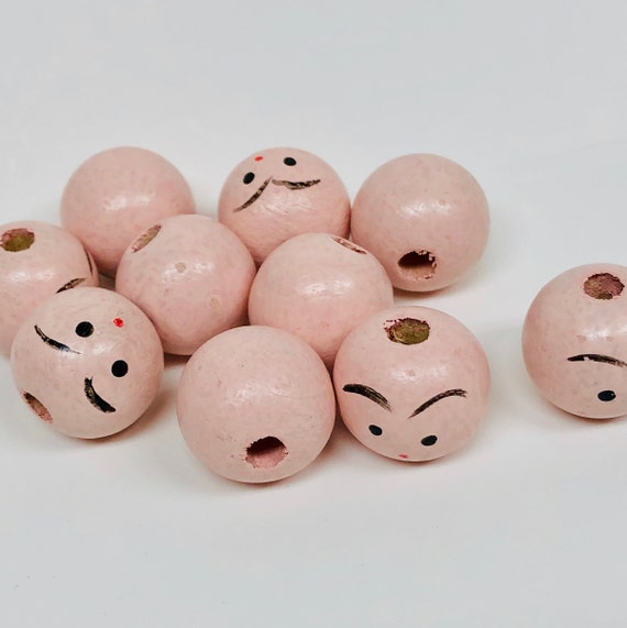 wooden doll heads with faces