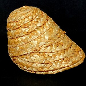 Pu&ograve; includere: Un cappello di paglia intrecciata con una corona arrotondata e una tesa curva. Il cappello &egrave; realizzato in paglia marrone chiaro e presenta un design strutturato e stratificato. Il cappello &egrave; probabilmente per la protezione solare.