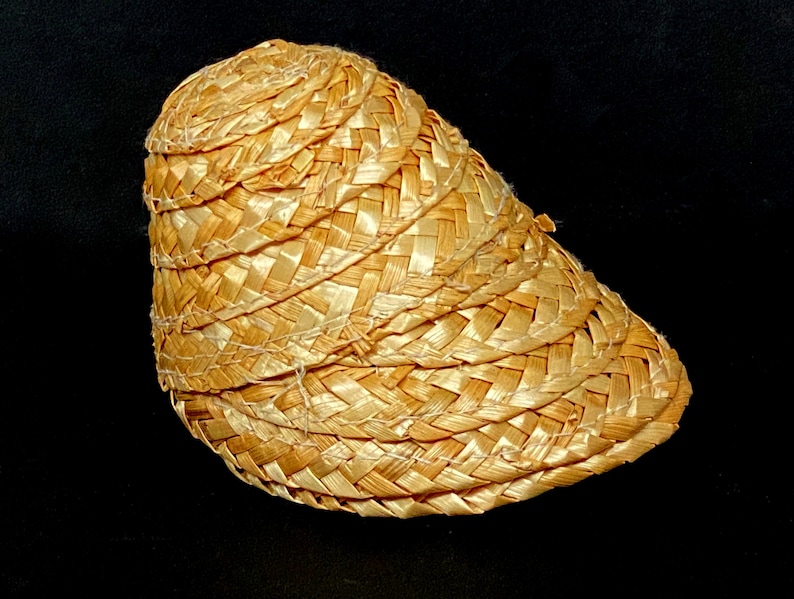 Pu&ograve; includere: Un cappello di paglia intrecciata con una corona arrotondata e una tesa curva. Il cappello &egrave; realizzato in paglia marrone chiaro e presenta un design strutturato e stratificato. Il cappello &egrave; probabilmente per la protezione solare.